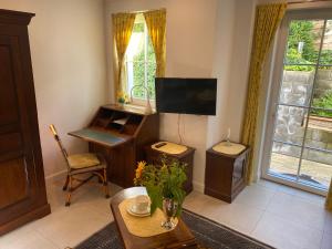 a living room with a tv and a table at Charmantes Einzelzimmer in Odenthal