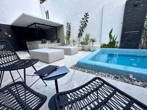 Un patio con dos sillas y una piscina. en Pachamaya Executive Wellbeing, en Cancún