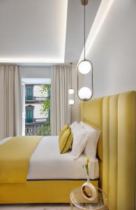 Incanto Suites Italy في نابولي: غرفة نوم بسرير أصفر ولوح رأس أصفر