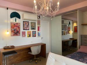 a bedroom with a desk and a bed and a chandelier at Cristal Studio Brooklin aero CGH Berrini in Sao Paulo +17 photos