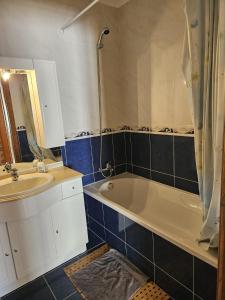 a bathroom with a bath tub and a sink at BigWaves2 in Nazaré