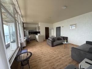 a living room with a couch and a table at Batumi seaside Magnolia in Batumi