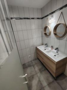 a bathroom with a sink and two mirrors at La Casa Beaujolaise in Charnay