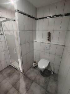 a white bathroom with a toilet and a shower at La Casa Beaujolaise in Charnay