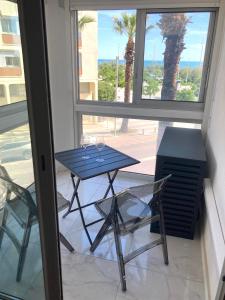 a table and two chairs in a room with a window at Appartement au coeur de la Grande Motte, vue mer in La Grande-Motte