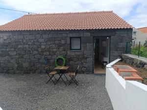 a stone house with a table and chairs in front of it at Casa da Miragaia in Maragaia