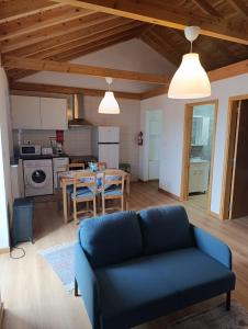 a living room with a blue couch and a table at Casa da Miragaia in Maragaia