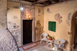 a room with two chairs and a table with a green shutter at Cavalieri in Masserano