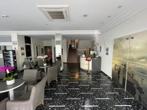 a lobby of a hotel with tables and chairs at HOTEL D'ANNUNZIO in Cattolica