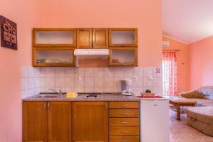 a kitchen with wooden cabinets and a white refrigerator at Apartments Villa Orange in Medulin +77 photos