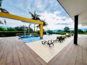a patio with benches and a pool with a yellow structure at La finca in La Mesa