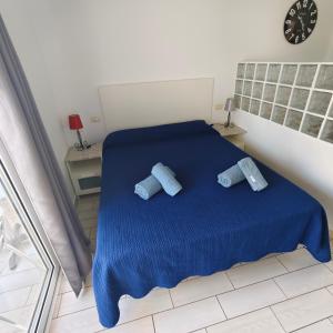 a bedroom with a blue bed with two blue pillows at Eldorado MILE STUDIO in Playa de las Americas +8 photos