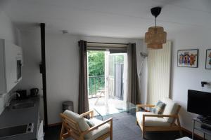 un soggiorno con divano, sedie e finestra di villa Flore, studio's a Bergen aan Zee