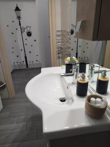 a bathroom with a white sink and a mirror at CAMARDA HOME in Bernalda +33 photos