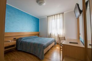 a bedroom with a bed and a desk and a table at Garni Castel Ferari in Tuenno