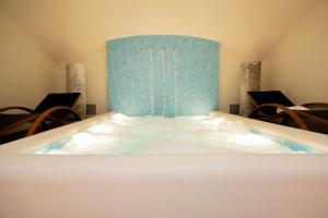 a jacuzzi tub in a room with chairs at Hotel Metropole Taormina in Taormina