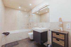 a bathroom with a sink and a toilet and a bath tub at NEU "Rügen Resørt Sagard" großzügiges, gemütliches Familienhaus "Alva" mit Terrasse in Sagard +25 photos