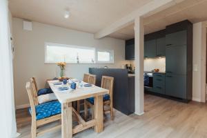 a kitchen and dining room with a table and chairs at NEU "Rügen Resørt Sagard" großzügiges, gemütliches Familienhaus "Alva" mit Terrasse in Sagard