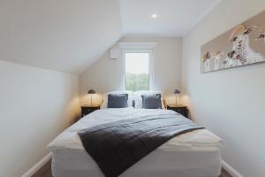 a bedroom with a large bed with two pillows at "Rügen Resort Sagard" großzügiges, gemütliches Familienhaus "Jördis" mit Terrasse in Sagard