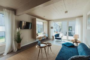 Una sala de estar con un sofá azul y una mesa. en NEU "Rügen Resørt Sagard" großzügiges, gemütliches Familienhaus "Line" mit Terrasse, en Sagard