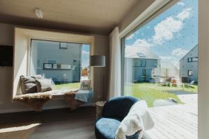 sala de estar con ventana grande y silla en NEU "Rügen Resørt Sagard" großzügiges, gemütliches Familienhaus "Line" mit Terrasse, en Sagard