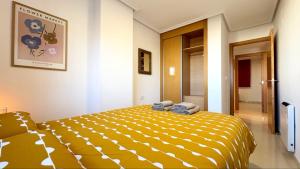 een slaapkamer met een geel bed en handdoeken bij Blue Horizon in Peñíscola