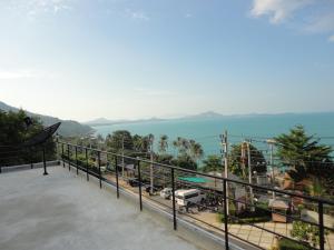 a balcony with a view of a city and the ocean at Pupha Mansion in Chaweng Noi Beach