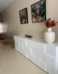 a white dresser in a room with two pictures on the wall at Apartamento cerca Playa in Sitges