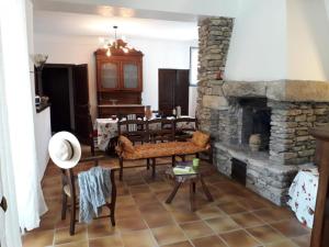 un salon avec une cheminée en pierre et une table dans l'établissement Au pied de la montagne, à Lioux