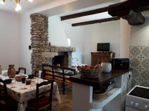 - un salon avec une table et une cheminée en pierre dans l'établissement Au pied de la montagne, à Lioux 22 autres photos
