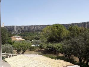 - une vue sur une montagne avec des arbres et un bâtiment dans l'établissement Au pied de la montagne, à Lioux