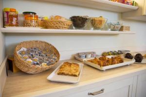 a kitchen counter with pastries and other foods on shelves at Garni Castel Ferari in Tuenno
