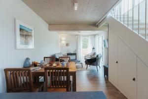a dining room and living room with a table and chairs at NEU "Rügen Resørt Sagard" großzügige, gemütliche Doppelhaushälfte "Linus" mit Terrasse in Sagard