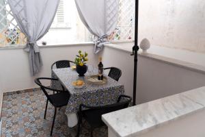 una mesa pequeña con sillas y una botella de vino en Le Tre Perle Ischia, en Isquia