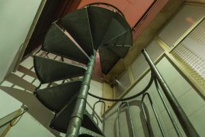 a spiral staircase in a building with an umbrella at Appartamento la strea in Torre Squillace