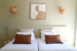 a bedroom with two beds with white sheets and brown pillows at HÖTEL U SANTA MARIA in Olmeto