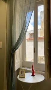 a window with a book and a red figurine on a table at La Casa Del Monsignore in Torre del Greco