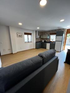 a living room with a couch and a kitchen at Casa ROSAMUNDA con gran jardín y cerca del mar in Santander