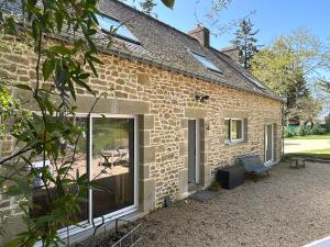 a brick house with a large sliding glass door at Maison de charme in Pluneret