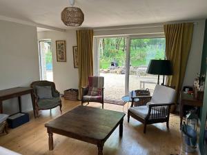 a living room with a coffee table and chairs at Maison de charme in Pluneret