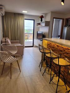 a living room with chairs and a kitchen with a counter at Sol morena 1 in Conde