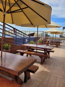 a group of picnic tables with umbrellas on a deck at Sol morena 1 in Conde