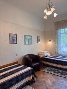 a hotel room with two beds and a chair at Green Villa in Pärnu