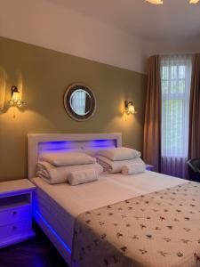 a bedroom with a white bed with a blue light at Green Villa in Pärnu