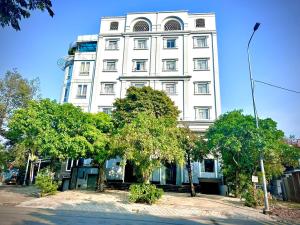 a tall white building with trees in front of it at I RiverSide 405B I Spacious Studio W Kitchen & Balcony in Ho Chi Minh City