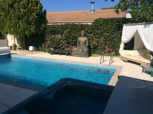 una statua accanto a una piscina con una statua di Villa ou studio indépendant PISCINE sans vis à vis a Mudaison