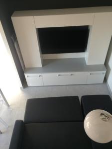 a living room with a black couch and a flat screen tv at Villa ou studio indépendant PISCINE sans vis à vis in Mudaison