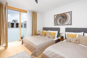 een slaapkamer met twee bedden en een groot raam bij Stylish Flat by the Metro in Praag