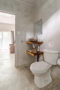 a bathroom with a white toilet in a room at Casa Yute in Talamanca
