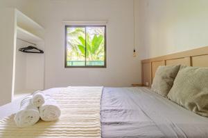 a bedroom with a bed with two towels on it at Casa Yute in Talamanca
